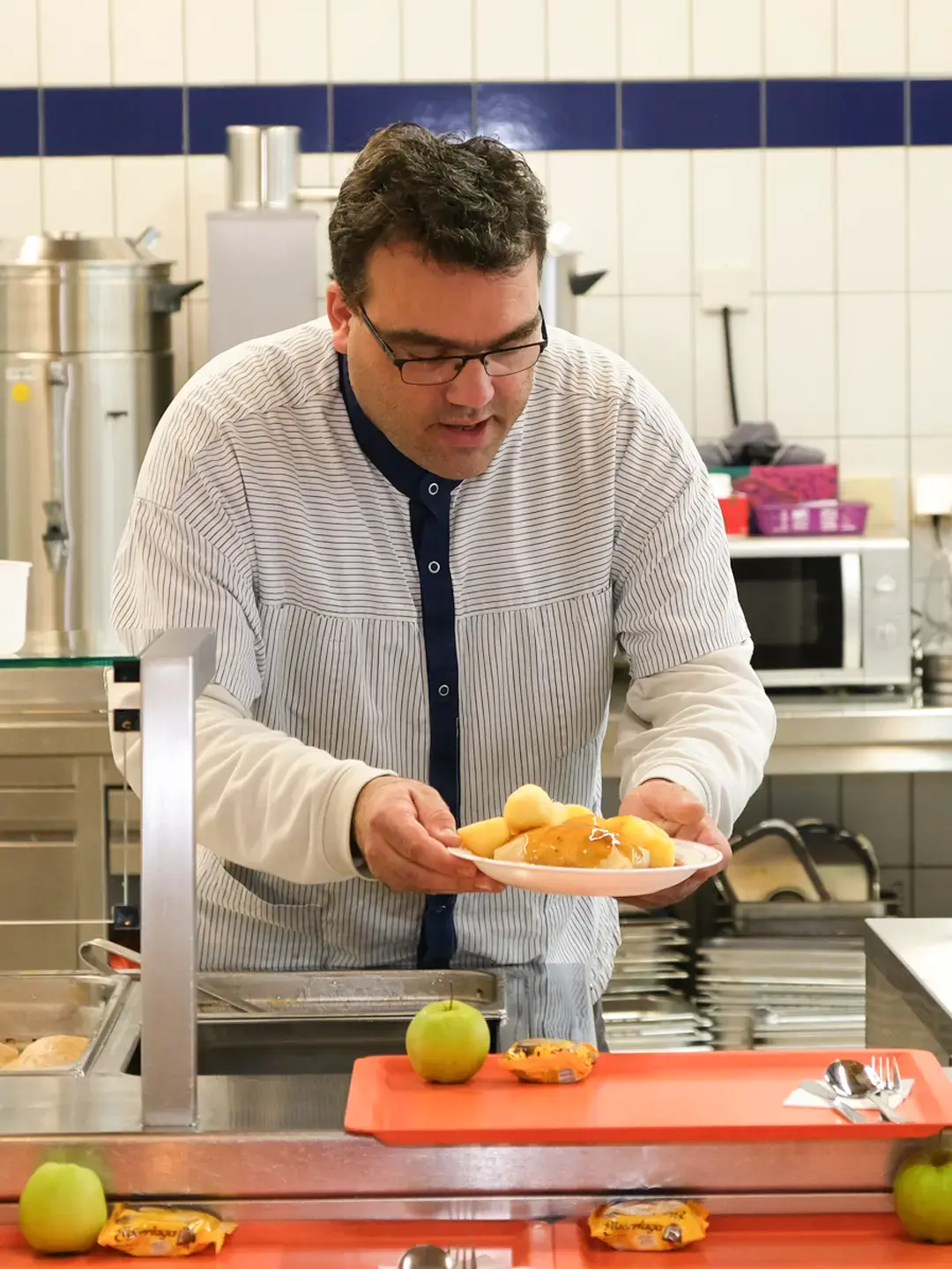 Mitarbeiter hinter dem Tresen bei der Essensausgabe in der Kantine