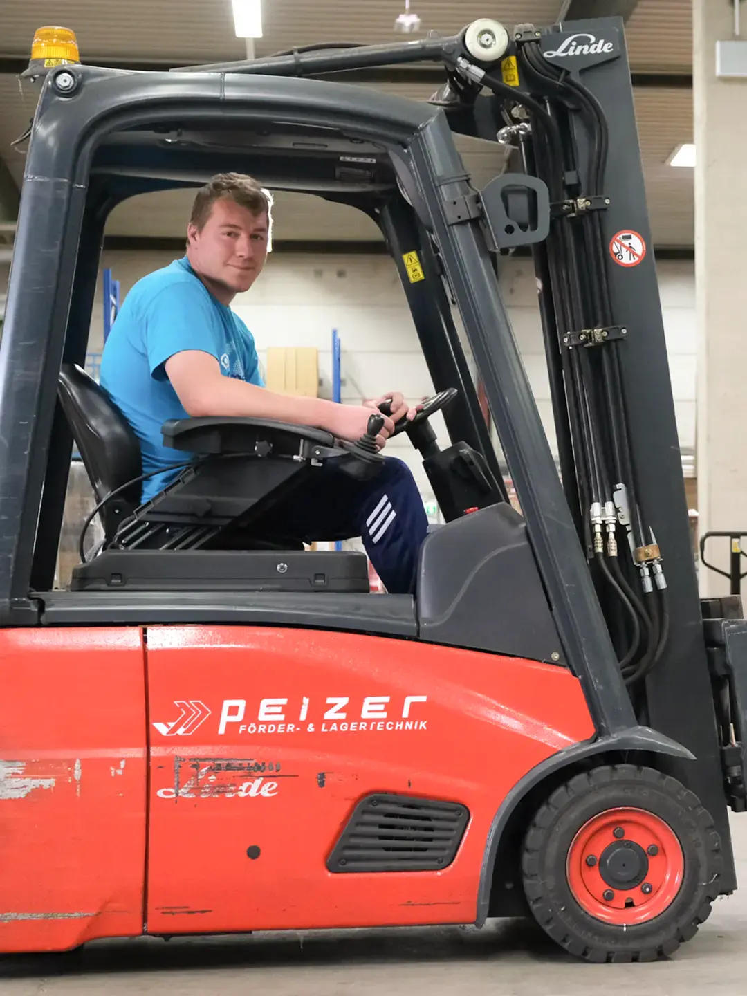 Mann befördert Teppichrolle mit Gabelstapler im Lager