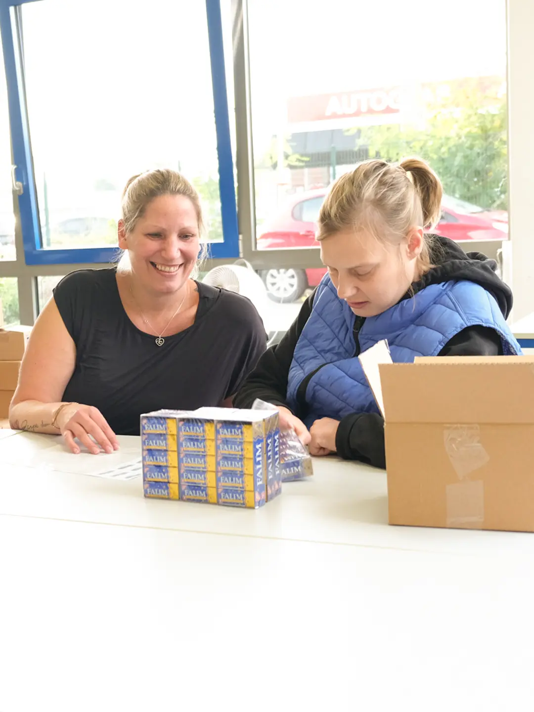 Zwei Personen bei Verpackungsarbeiten am Tisch