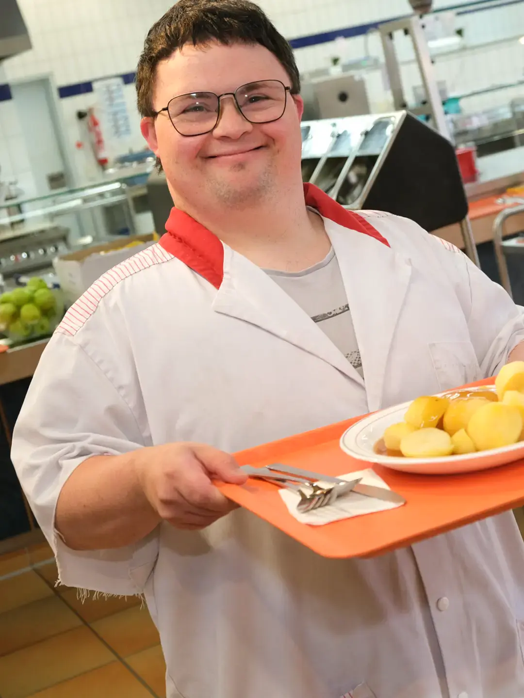 Werkstattbeschäftigter mit Speisetablett auf dem Weg zum Essen in der Kantine