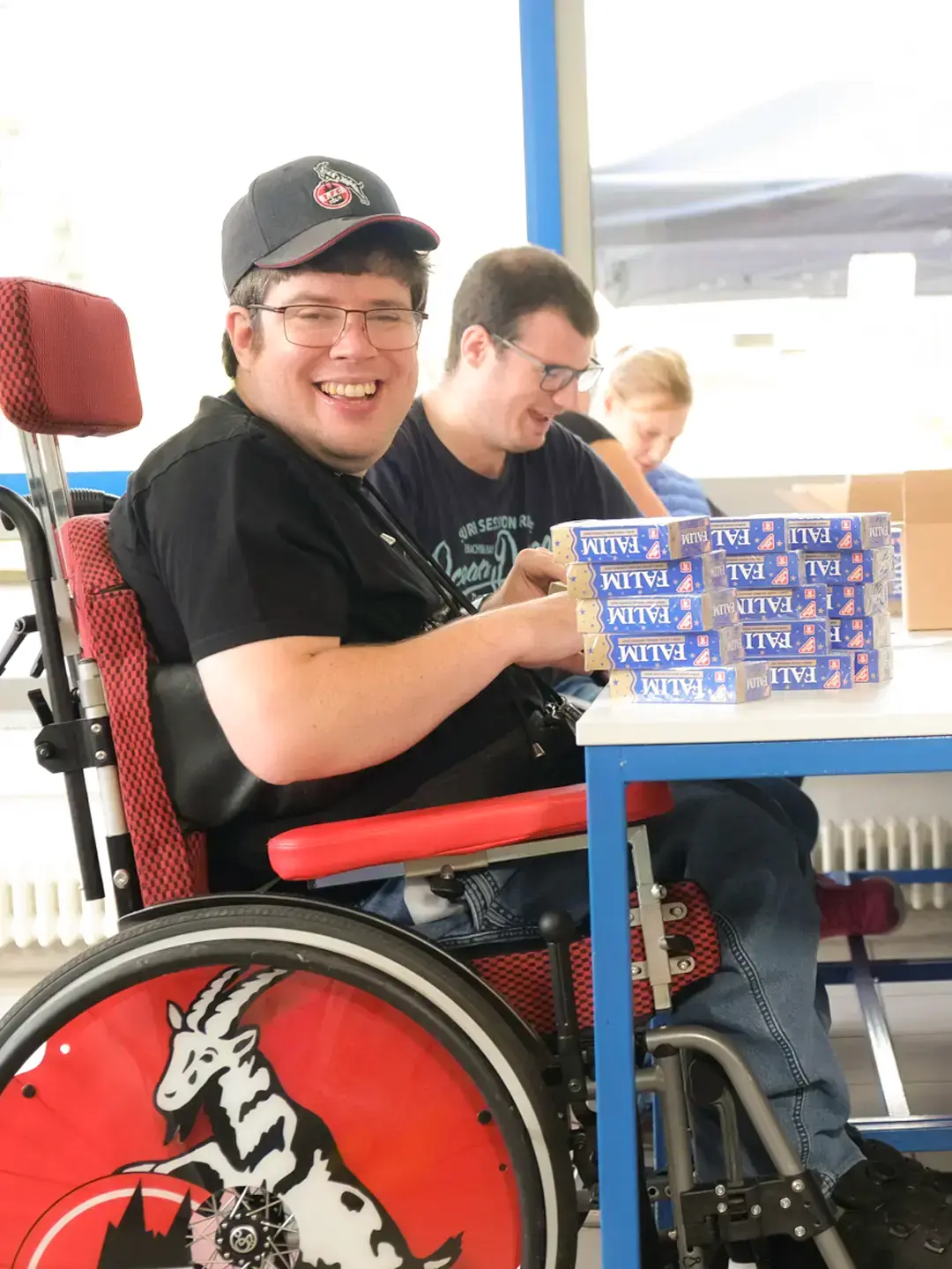 Ein Team bearbeitet Kaugummi-Verpackungen an einem Tisch.