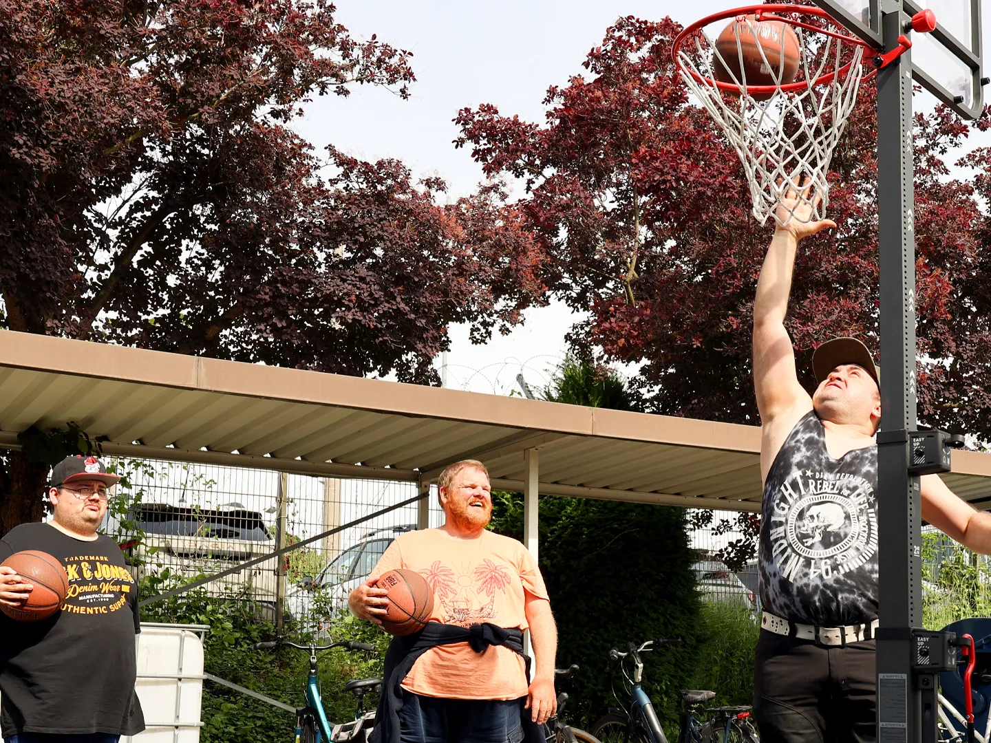 Drei Männer beim Basketballtraining am Korb