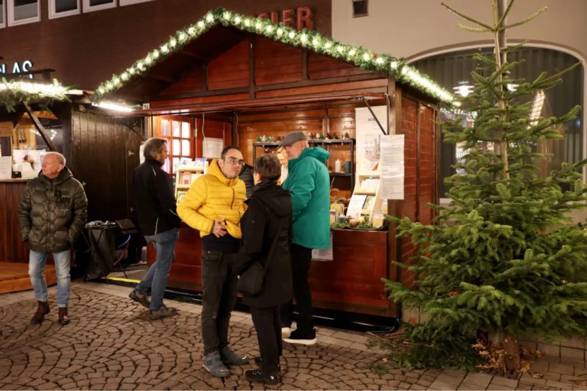 Die Weihnachtsmarkt-Bude der REHA-Betriebe Erftland auf dem Weihnachtsmarkt in Brühl ist umringt von interessierten Besucher*innen.