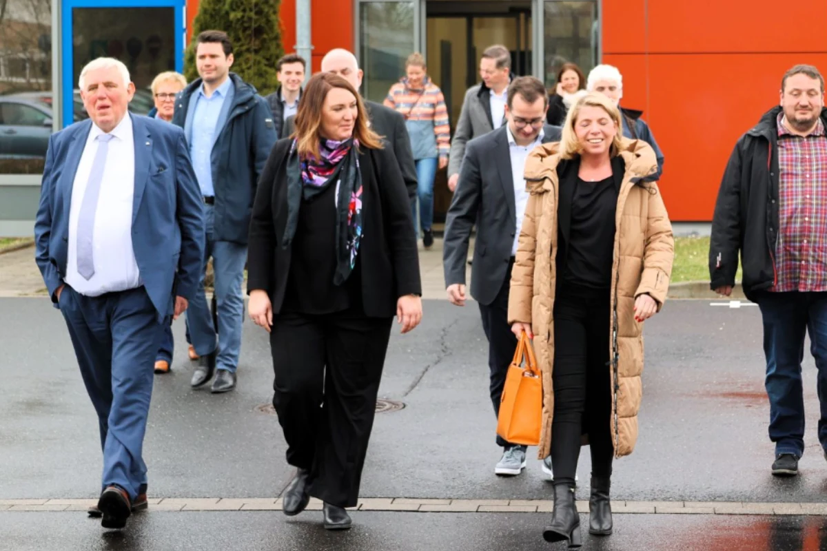 Herr Minister Laumann verlässt mit unseren Mitarbeitenden und weiteren Besuchern eines unserer Gebäude. Die Gruppe besteht aus etwa zehn Personen.