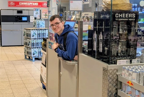 Fabian an seinem Arbeitsplatz im REWE: der Kasse.